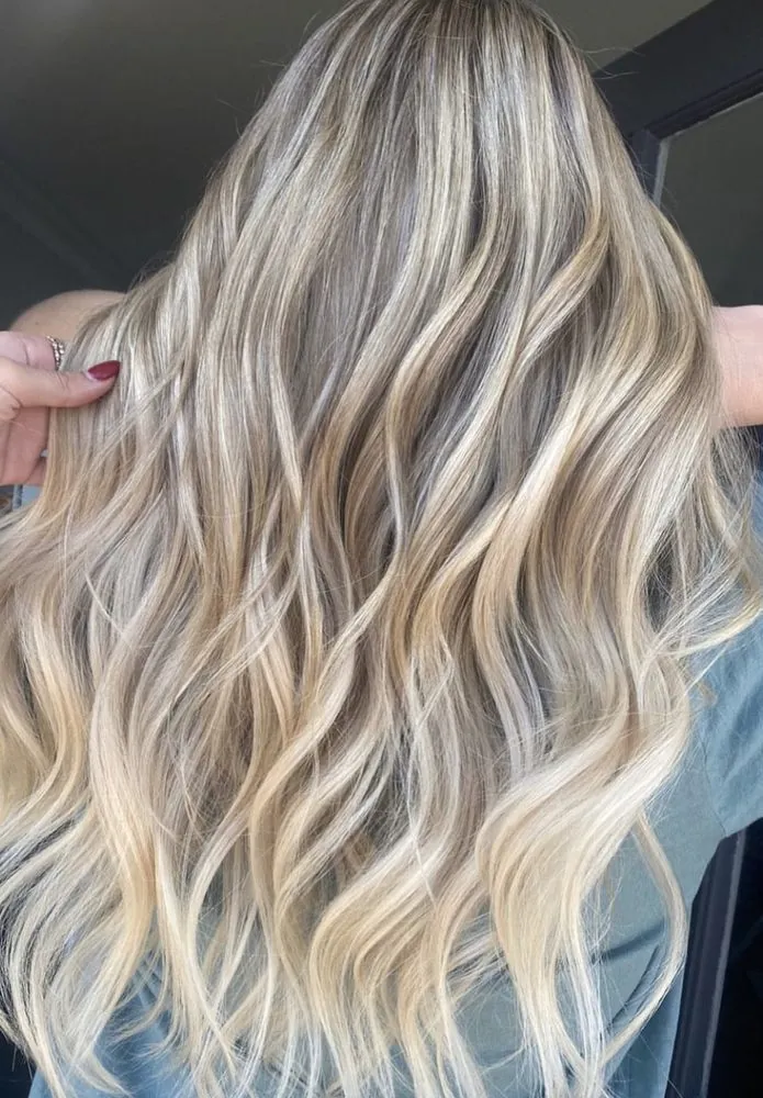 Dimensional blonde balayage with luminous ribboning through soft waves — recent work from The Beauty Suite.